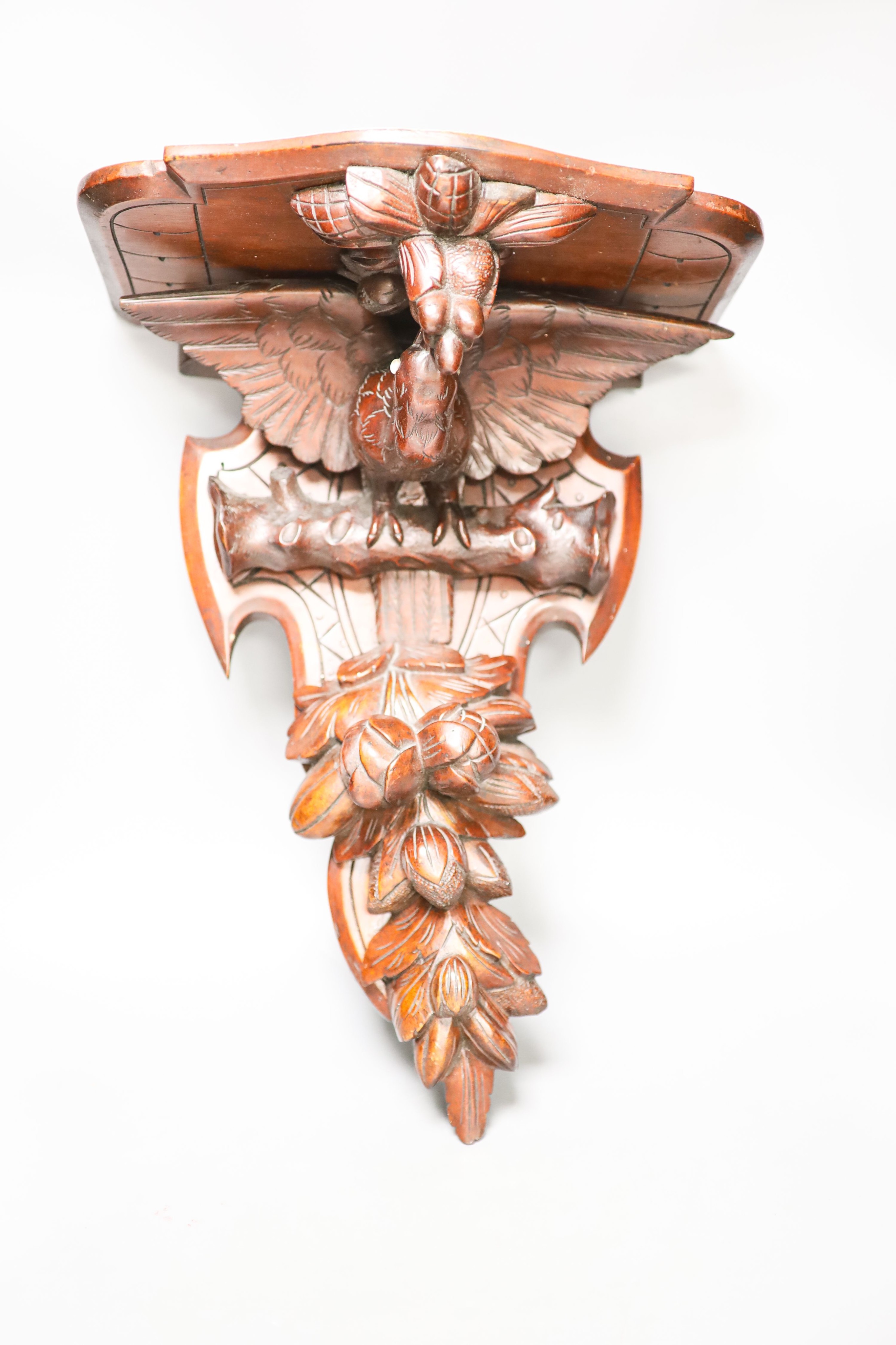 A late 19th century carved mahogany ‘eagle’ wall bracket with glass eyes 51cm